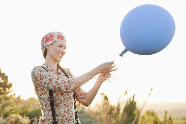 Счастливая женщина играет с воздушным шаром в природе — стоковое фото