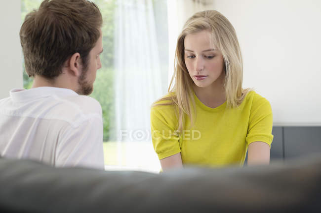 Молода пара сидить вдома і розмовляє — стокове фото