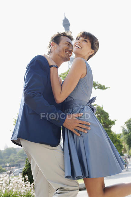Romantisches paar, das sich mit dem eiffelturm im hintergrund umarmt, paris, ile-de-france, france — Stockfoto