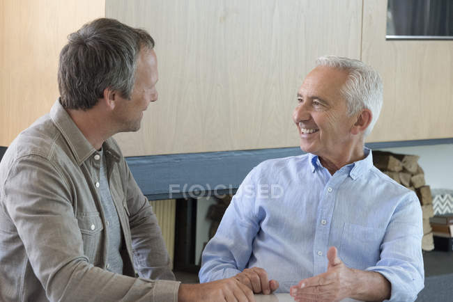 Старший чоловік обговорює з фінансовим радником вдома — стокове фото