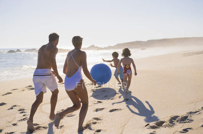 Famiglia che gioca con un pallone da spiaggia — Foto stock