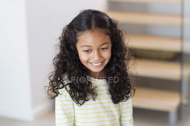 Primer plano de la niña feliz sonriendo en casa - foto de stock