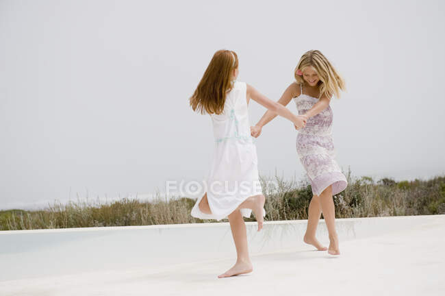 Duas raparigas a brincar à beira da piscina — Fotografia de Stock