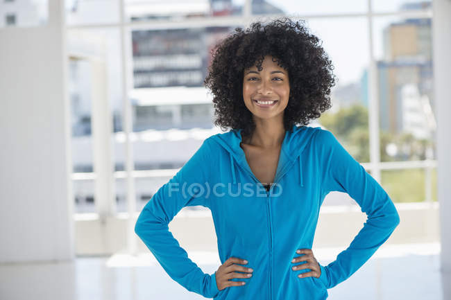 Portrait of smiling woman standing with hands on hips — Stock Photo