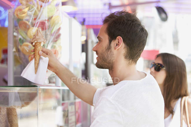Man taking ice cream from ice cream parlor — Stock Photo