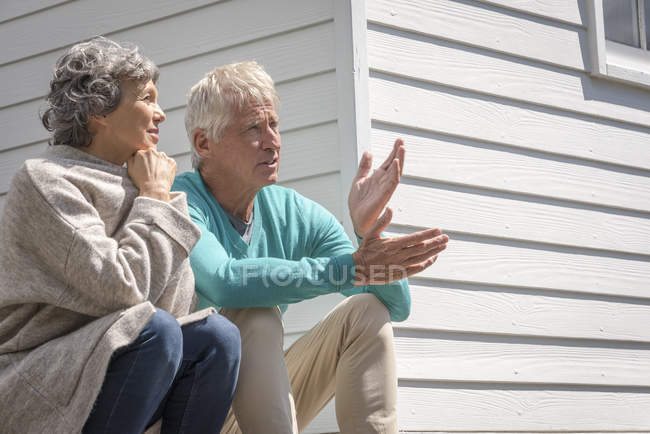 Couple âgé parlant à l'extérieur de la maison — Photo de stock