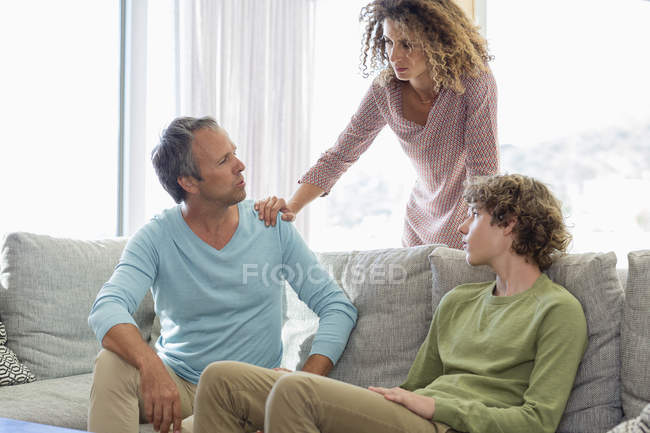 Семья, обсуждающая дома в гостиной — стоковое фото