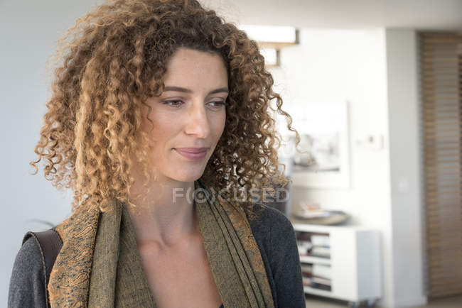 Gros plan de femme réfléchie aux cheveux bouclés regardant ailleurs — Photo de stock