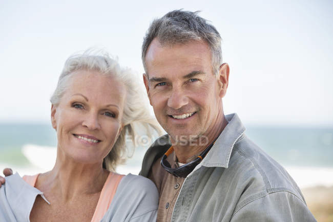 Porträt eines glücklichen Paares, das entspannt am Strand steht — Stockfoto