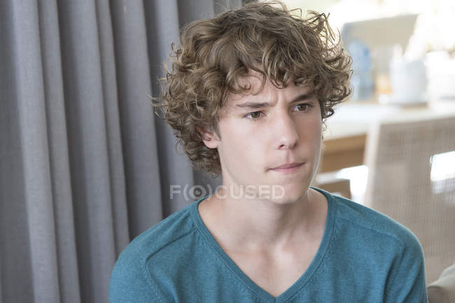 Close-up of teenage boy with curly hair thinking — Stock Photo