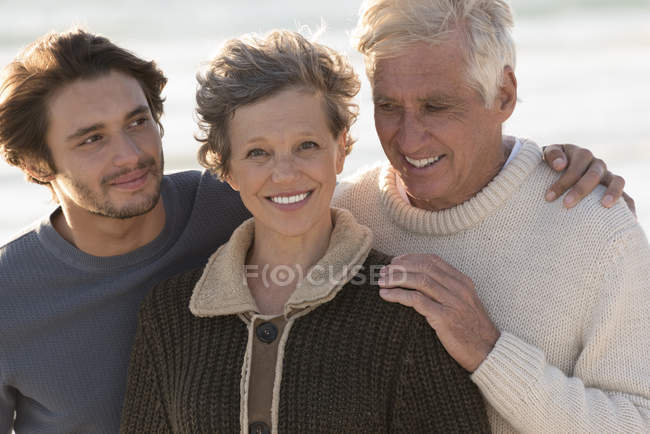 Портрет счастливой семьи, стоящей на пляже вместе — стоковое фото