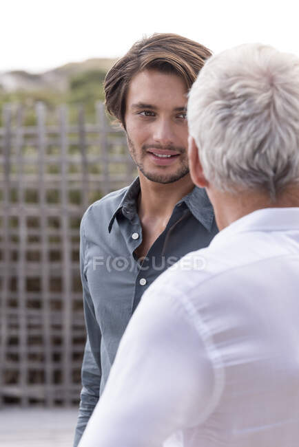 Счастливые отец и сын разговаривают снаружи — стоковое фото