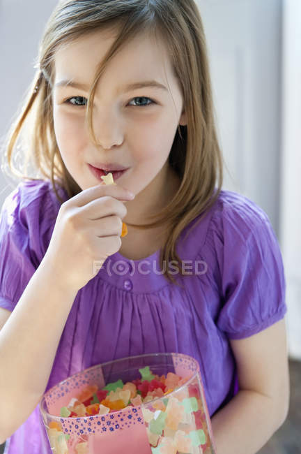 Kleines Mädchen hält Schachtel voller Gummibonbons — Stockfoto