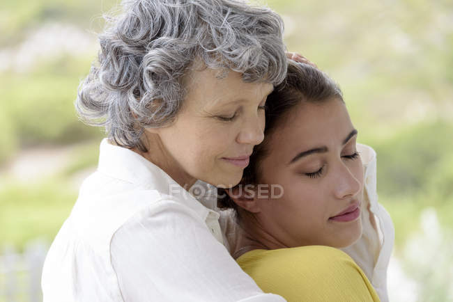 Liebevolle Mutter umarmt erwachsene Tochter im Freien — Stockfoto