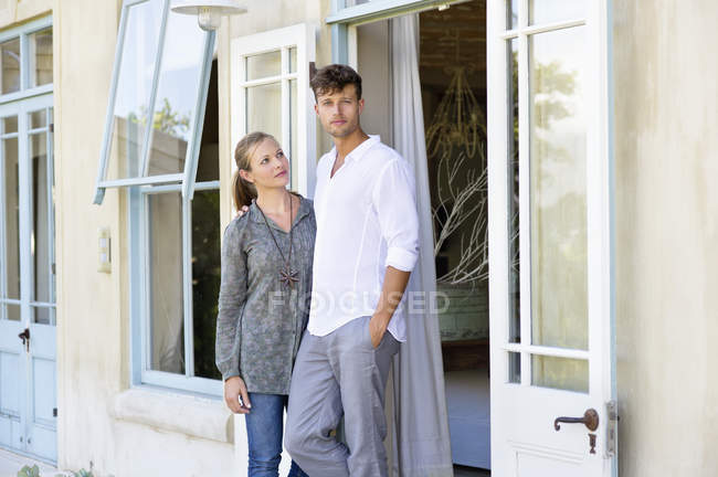 Молода пара стоїть разом перед будинком — стокове фото