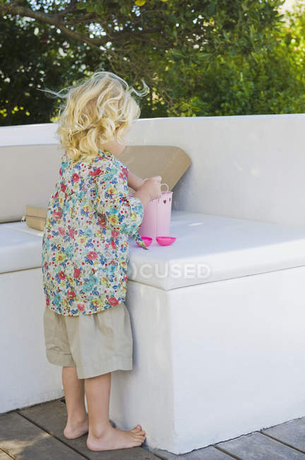 Linda menina brincando com balde no jardim de verão — Fotografia de Stock