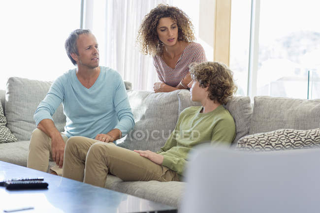 Família descansando e conversando na sala de estar em casa — Fotografia de Stock