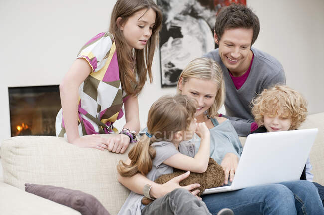 Familia usando un portátil - foto de stock