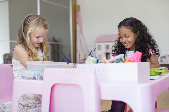 Cheerful little girls doing homework at house — Stock Photo