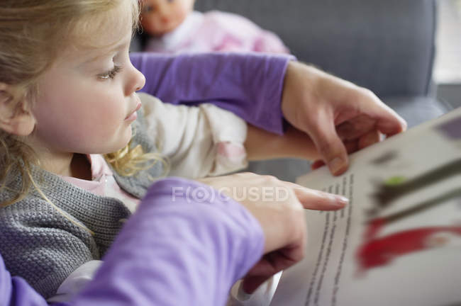 Primer plano de niña estudiando con padre en casa - foto de stock