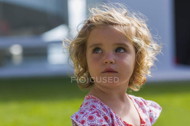 Primer plano de linda niña sosteniendo mirando al aire libre - foto de stock