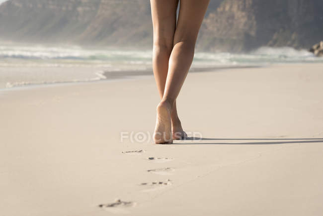 Pernas finas de mulher andando na praia arenosa — Fotografia de Stock