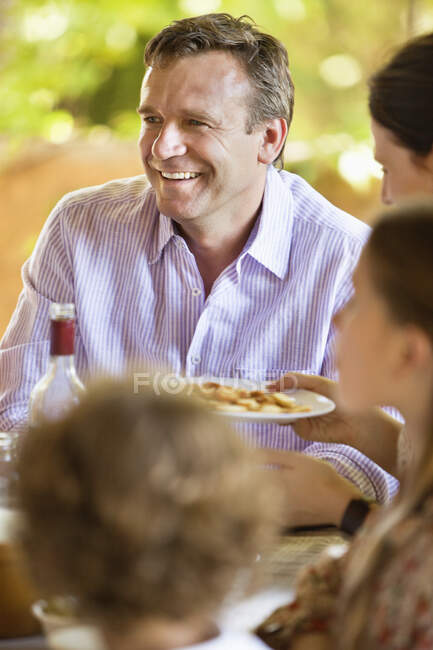 Family having meal and discussing at dining table — Stock Photo