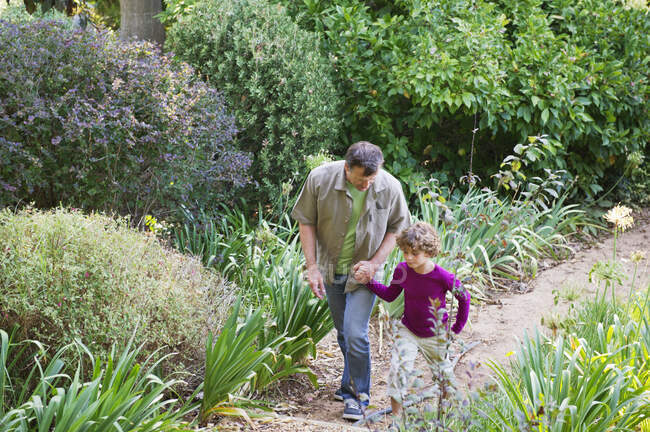 Отец и сын гуляют в саду — стоковое фото