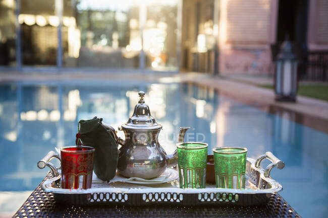Silberne Teekanne mit Trinkgläsern am Pool, Marrakesch, Marokko — Stockfoto