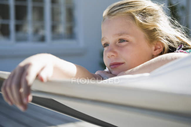 Close-up of dreamy little girl resting on deckchair — Stock Photo