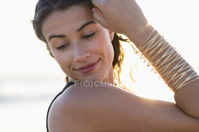 Чуттєва молода жінка позує на пляжі — стокове фото