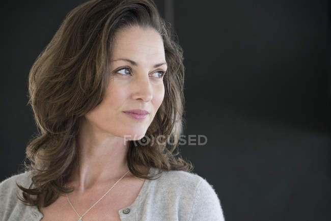 Close-up of mature woman looking away on black background — Stock Photo