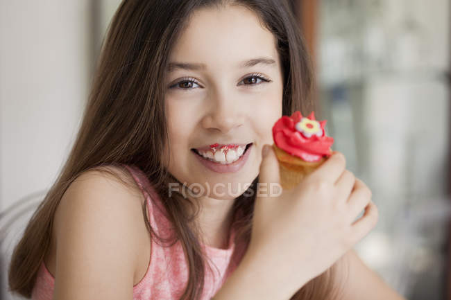Portrait of happy girl holding sweet cupcake — Stock Photo
