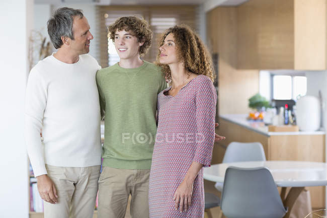 Retrato de familia feliz de pie en casa - foto de stock