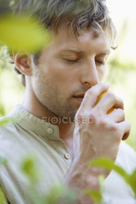 Close-up of man smelling fresh lemon outdoors — Stock Photo