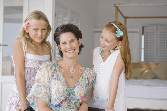 Femme souriant avec ses deux filles — Photo de stock