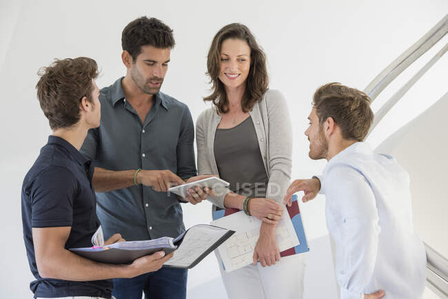 Happy businesswoman standing with her colleagues on staircase — Stock Photo
