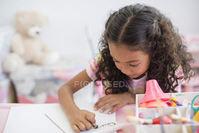 Зосереджено маленька дівчинка, робити домашнє завдання в таблиці — стокове фото