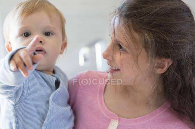 Mädchen mit ihrem Bruder lächelt zu Hause — Stockfoto