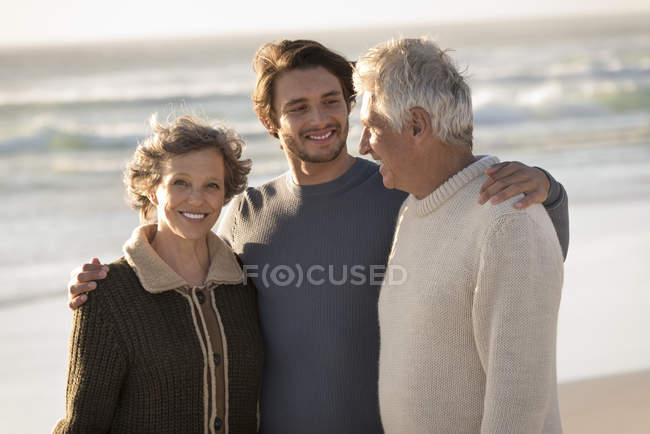 Portrait of happy family standing on beach together — Stock Photo