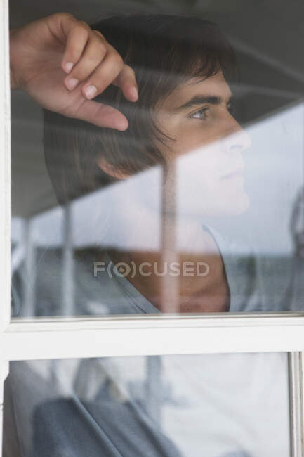 Человек смотрит через стеклянное окно — стоковое фото