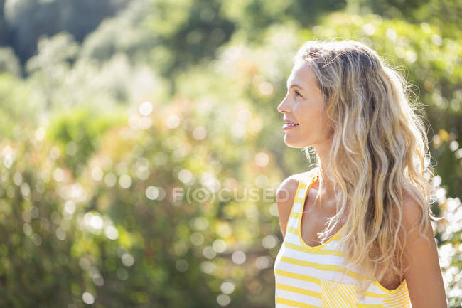 Sorridente donna rilassata in piedi nel parco — Foto stock