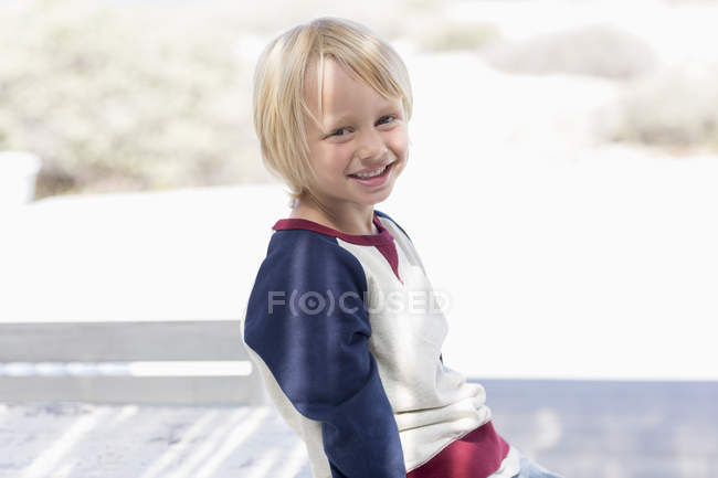 Retrato de niño feliz sonriendo al aire libre a la luz del sol - foto de stock