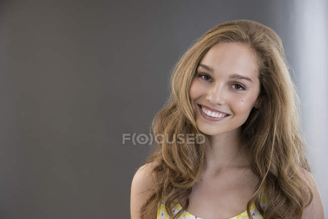 Retrato de menina adolescente feliz no fundo cinza — Fotografia de Stock