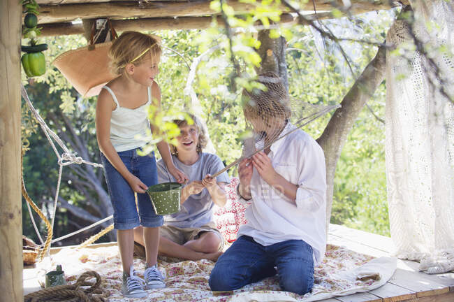 Niños jugando en la casa del árbol - foto de stock