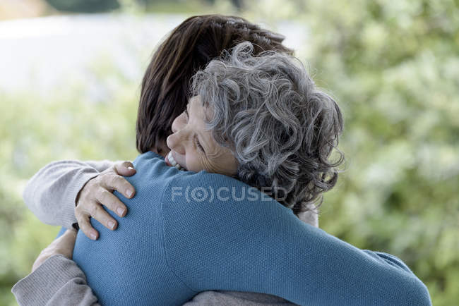 Filho amoroso abraçando mãe ao ar livre — Fotografia de Stock