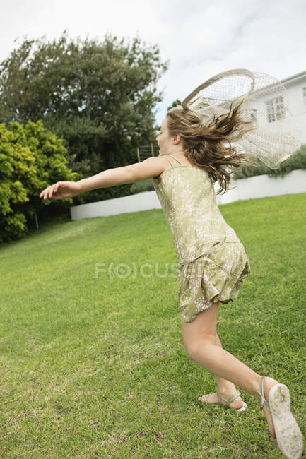 Mädchen spielt mit Schmetterlingsnetz im Sommergarten — Stockfoto