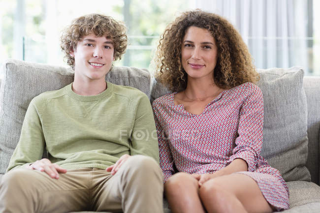 Портрет щасливої матері і сина, що сидить на дивані у вітальні — стокове фото
