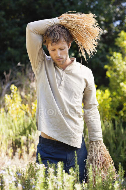 Bored man standing in field as scarecrow — Stock Photo