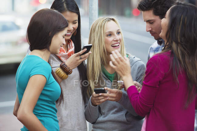 Amigos usando telefones celulares ao ar livre — Fotografia de Stock